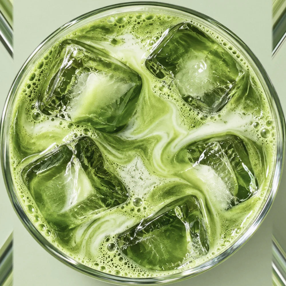 An iced matcha latte seen from above, swirls of milk through bright green matcha and ice